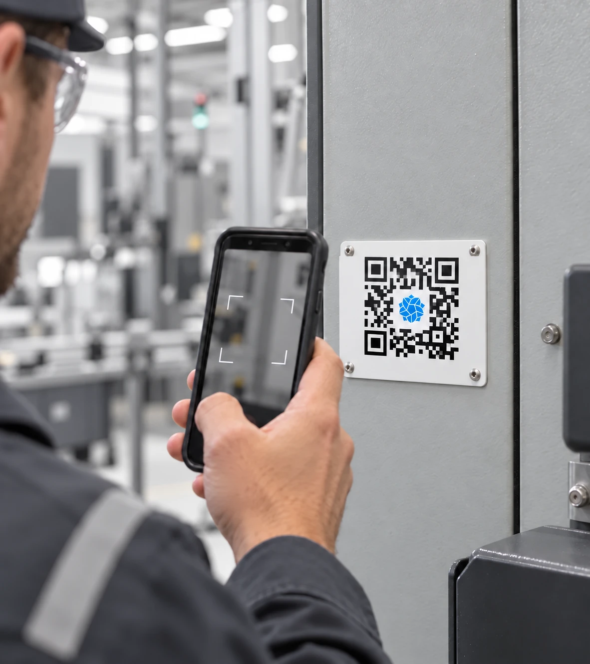 Technician scanning a Vedae QR code on equipment beside a production line